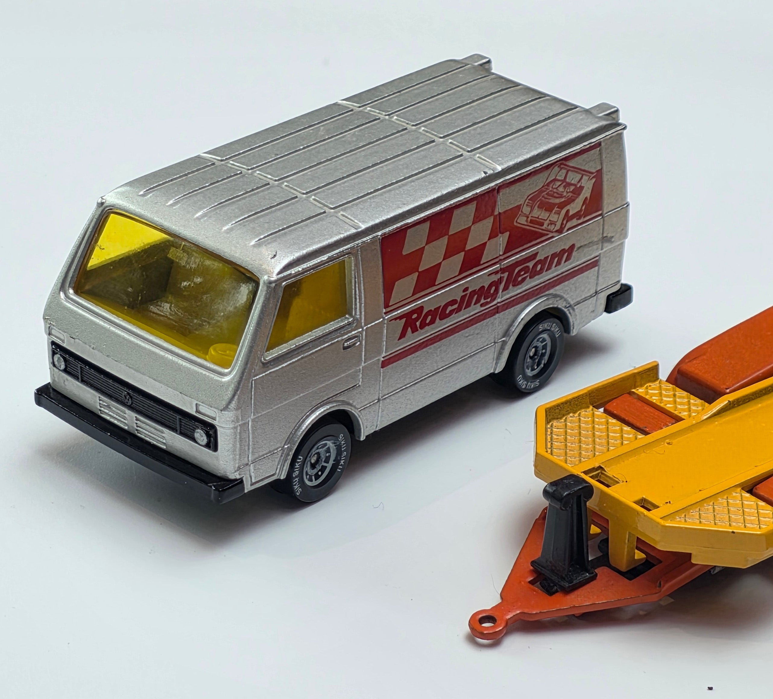 Vintage Siku 2217 Volkswagen LT28 diecast model transporter set featuring a metallic grey racing team van and a trailer carrying a McLaren race car.