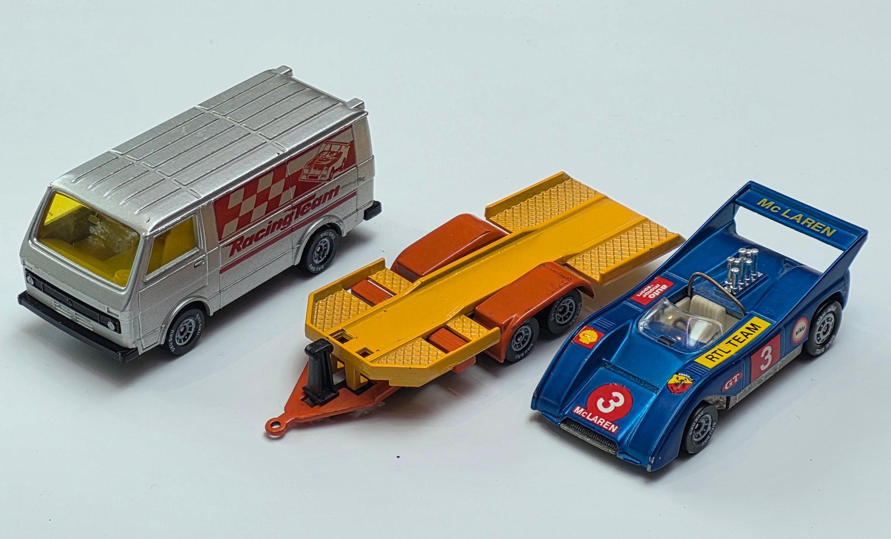 Vintage Siku 2217 Volkswagen LT28 diecast model transporter set featuring a metallic grey racing team van and a trailer carrying a McLaren race car.
