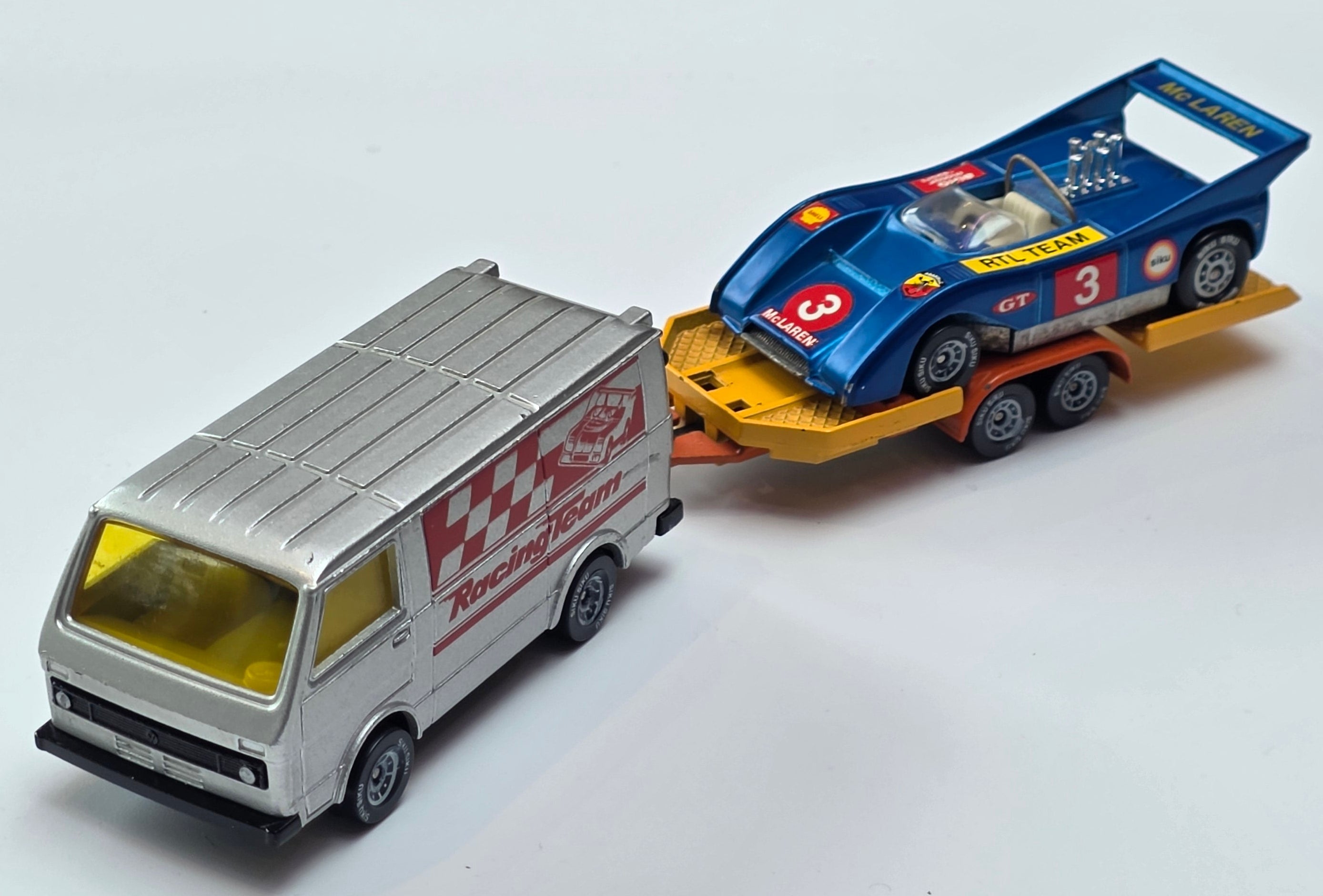 Vintage Siku 2217 Volkswagen LT28 diecast model transporter set featuring a metallic grey racing team van and a trailer carrying a McLaren race car.